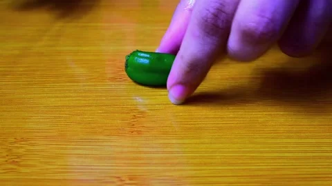 Closeup Top Shot of Cutting Green Chilies on Wooden Cutting Board HD Stock Footage 149381638