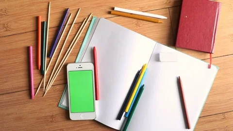 Closeup top view of chroma-key smart phone mobile and colorful pencils with open Видео 89772853