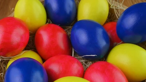 Closeup top view Colorful easter eggs lie on a bacon in a basket. Stock Footage 125616610
