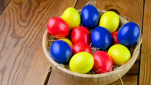 Closeup top view Colorful easter eggs lie on a bacon in a basket Stock Footage 125616617