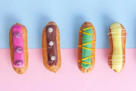 Closeup top view of eclairs on pink-blue background Stock Photos
