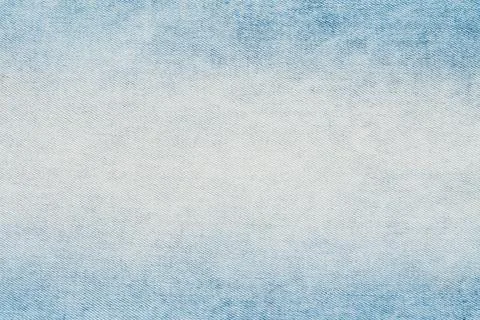 Closeup top view of light blue denim fabric. Stonewashed jeans material shows 库存照片