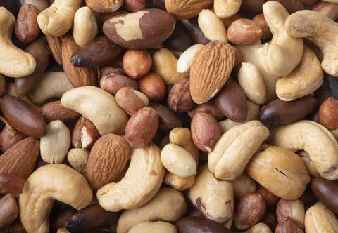 Closeup top view of mixed nuts over a wooden background. Peanuts, brazilian n Stock Photos