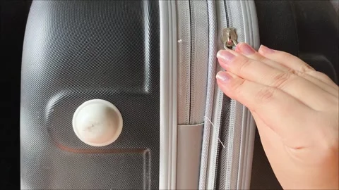 Closeup top view of silver zipper of hard shelled suitcase, new and clean Stock Footage 313833637