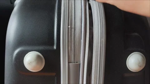 Closeup top view of silver zipper of hard shelled suitcase, new and clean Stock Footage 313833661