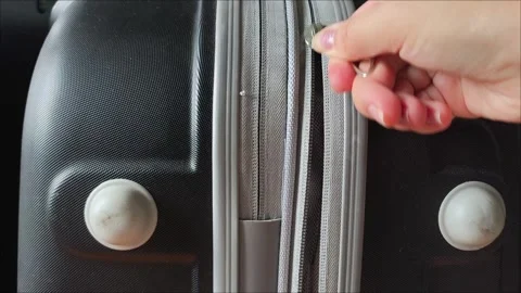 Closeup top view of silver zipper of hard shelled suitcase, new and clean Stock Footage 313833680