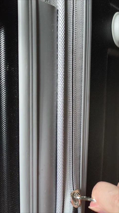 Closeup top view of silver zipper of hard shelled suitcase, new and clean Stock Footage 313833817