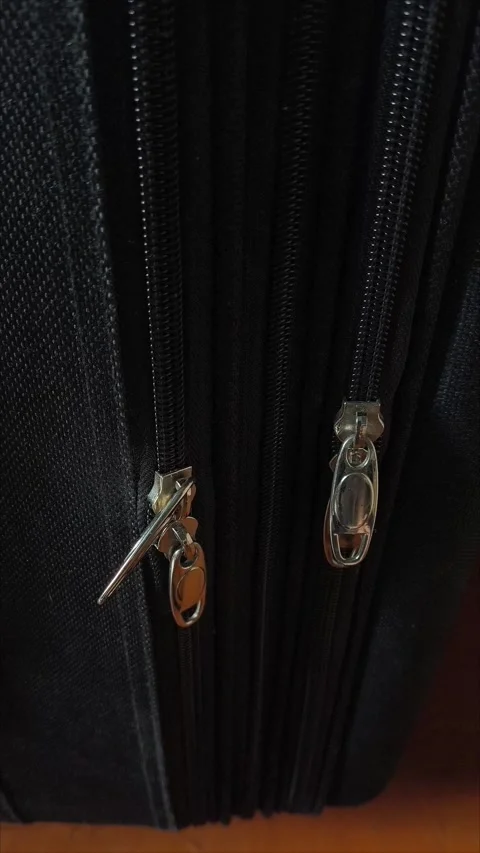Closeup top view of silver zipper of hard shelled suitcase, new and clean Stock Footage 313833856