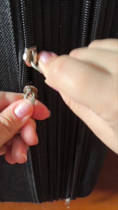 Closeup top view of silver zipper of hard shelled suitcase, new and clean 스톡 동영상 313833909