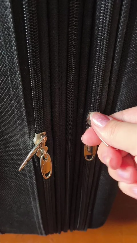 Closeup top view of silver zipper of hard shelled suitcase, new and clean Stock Footage 313833915
