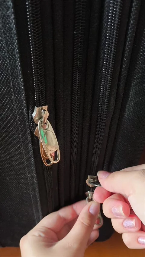 Closeup top view of silver zipper of hard shelled suitcase, new and clean Stock Footage 313833978