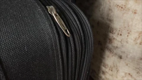 Closeup top view of silver zipper of hard shelled suitcase, new and clean Video stock 313834029