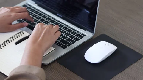 Closeup top view of a simulated pose person typing on the keyboard on a laptop Stock Footage 319512990