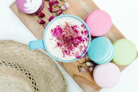 Closeup top view on straw hat and blue cup of aroma cappuccino with french ta Stock Photos