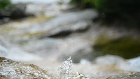 Closeup of the top a waterfall with drops squirting (slow motion, bokeh) Video stock 212742857