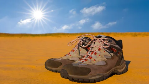 Closeup touristic boot stay on sand under sparkle sun time lapse scene Video stock 253984953