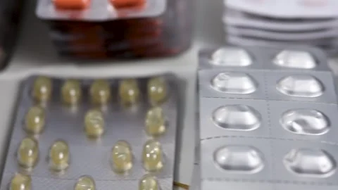 Closeup tracking shot alongside desk full of medication blisters Video stock 286218670