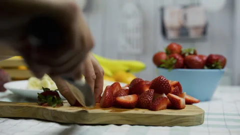 Closeup tracking shot of chef cutting strawberries on board Stock Footage 341198307