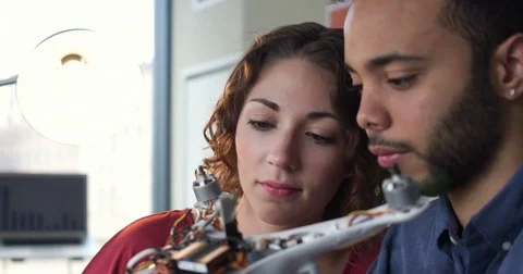Closeup Tracking Shot of Man and Woman Wiring Together A Quadcopter For Tests In 스톡 동영상 82676285