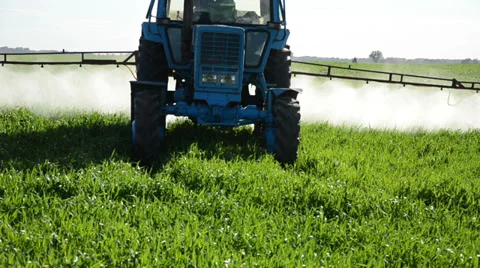 Closeup tractor spray green field with pesticide chemicals Stock Footage 33355363