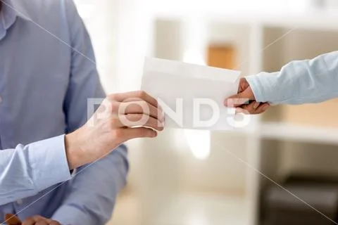 Closeup transfer of envelope from hand to hand Stock Photos