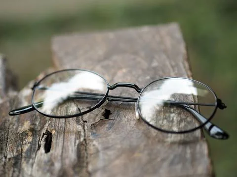 Closeup of transparent eyeglasses with round frames on a wooden surface Foto stock