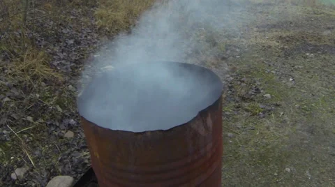 Closeup of trash burning in a smoking, rusty barrel, Stock Footage 33714049