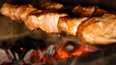 Closeup of turning meat skewers while roasting on charcoal grill Stock Footage 104506031