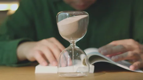 Closeup Turning Sandglass to Start Deep Work and Studying Literature Stock Footage 338321850