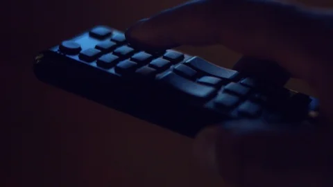 Closeup of tv controller and man's hand pushing buttons Stock Footage 87249384