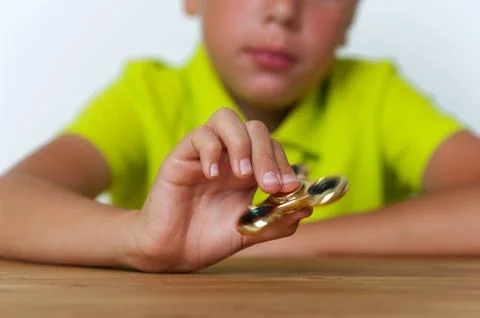Closeup of tween boy playing with fidget spinner Stock Photos