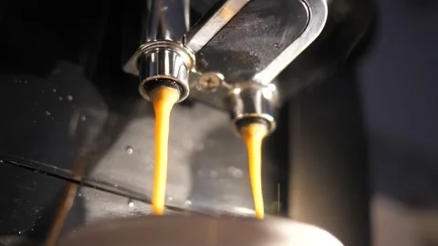 Closeup two coffee jets pouring into a cup from espresso machine in slow motion  Stock Footage 167894930