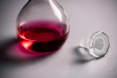 Closeup of two conical erlenmeyer flasks with red liquid and a glass plug. Stockfoto's