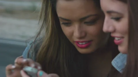 Closeup Of Two Friends Sharing A Smart Phone Video stock 35757614