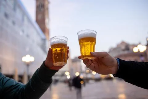 Closeup of two hands clinking beer stein glasses. Stock Photos