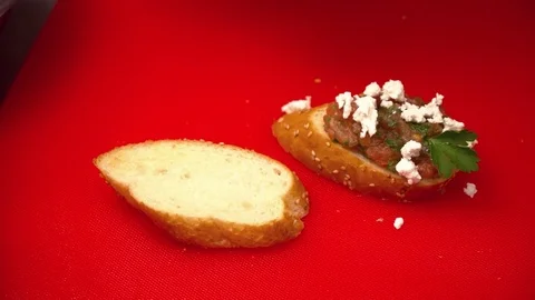 Closeup of two hands making tapas with tomato Stock Footage 77025574