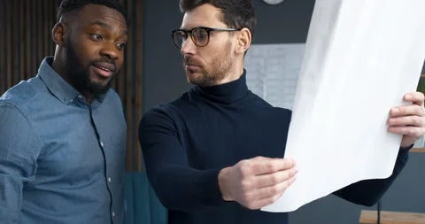 Closeup of Two inspired Architects, Startupers are working with Blueprints. Two Stock Footage 126162268