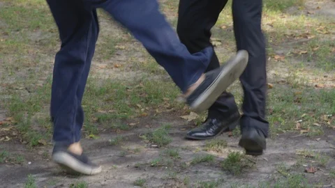 Closeup - Two men dance around playfully with each other at the park - shot on Stock Footage 124718325