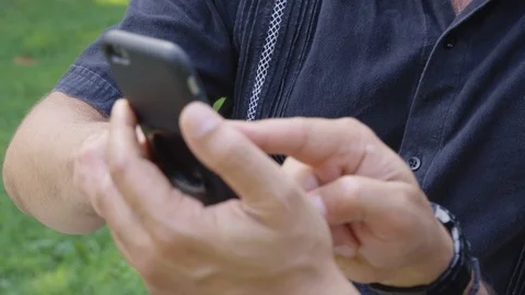 Closeup - Two men show each other a video on a phone while outside - shot on RED Stock Footage 124717589