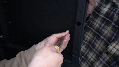 Closeup of two men trying to put a screw to a plastic door  Stock Footage 140756325