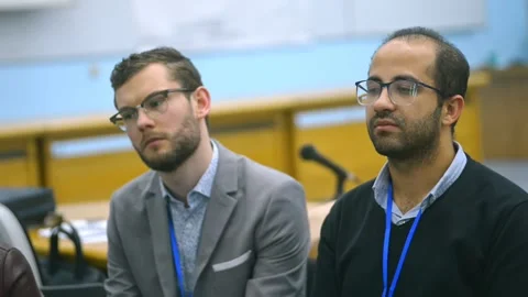 Closeup of two middle age men in conference hall audience on business training Stock Footage 139057132