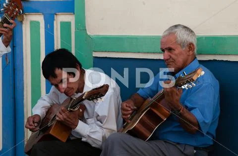 Closeup Of Two Old Man Playing Guitar On The Street Making Music