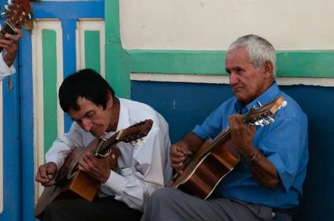 Closeup of two old man playing guitar on the street making music Stock Photos