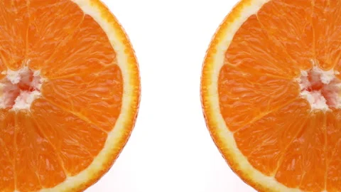 Closeup of two orange slices rotating. Isolated on white background. Stock Footage 158912416
