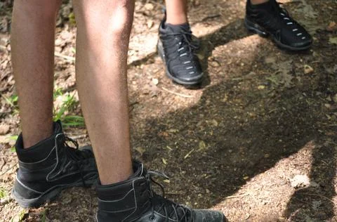 Closeup of two pair of black canvas and black tennis shoes Foto stock