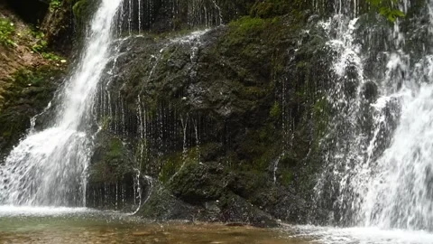 Closeup of the of a twofold waterfall in a forest, slow motion Video stock 260936007