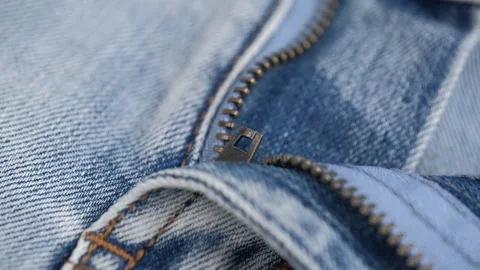 Closeup unbuttoned zipper on jeans. rotating fabric of blue jeans in details. Stock Footage 252159041