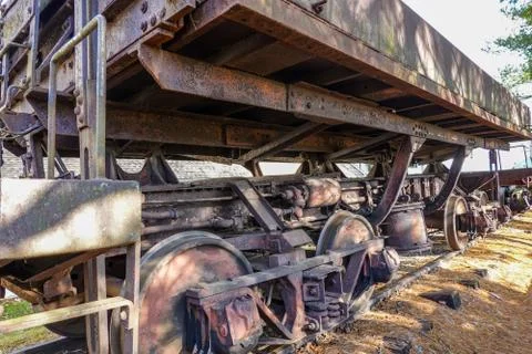 Closeup of the undercarriage of an old rusted elevated flatbed locomotive car Stock Photos