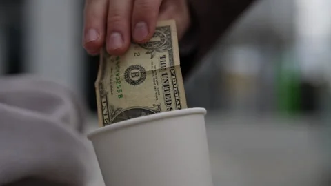 Closeup of unrecognizable kind man giving paper money to homeless beggar male Stock Footage 290478685