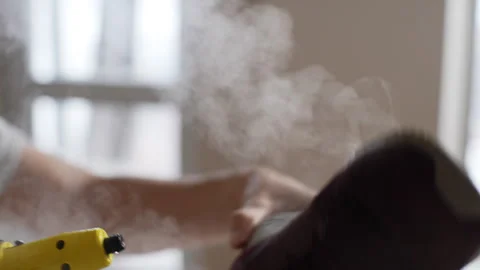 Closeup of unrecognizable man disinfects inside of sneakers with hot steam using Stock Footage 267641152